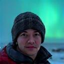 Solo traveler Kenji Tanaka with the northern lights in the background